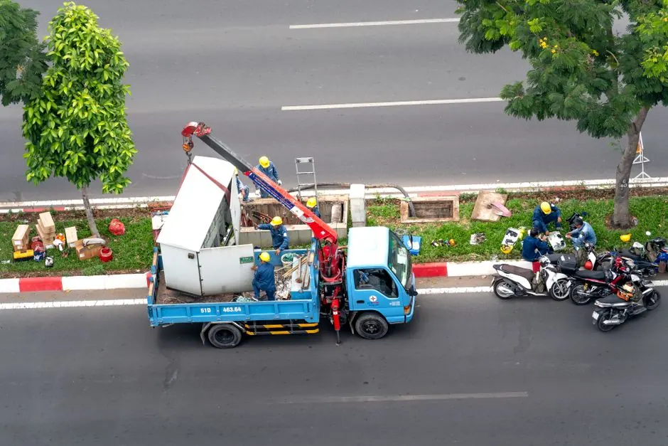 Overhead shot of workers with a truck and motorcycles on a city street.